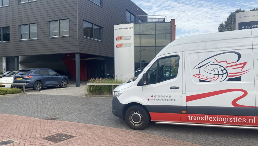 Een Transflex Logistics bestelwagen bij een bedrijfspand